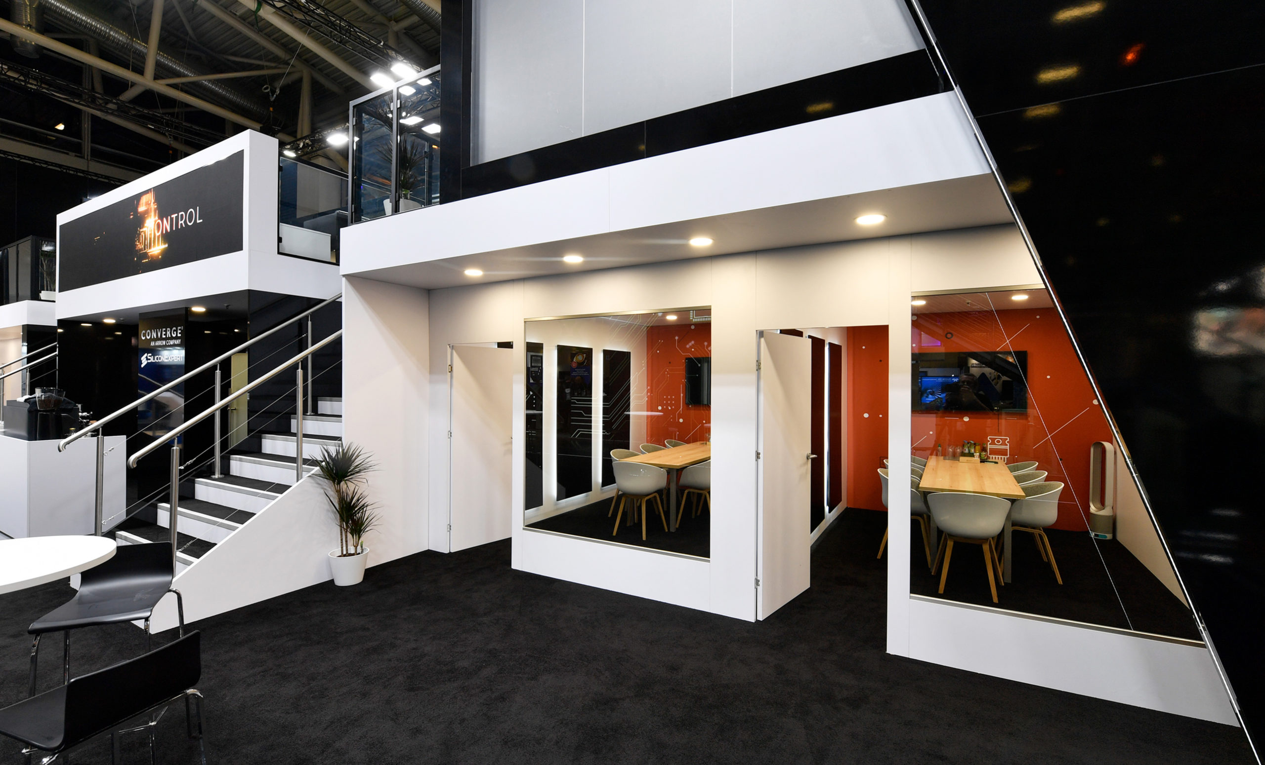 Custom trade show exhibit display by Converge featuring private meeting rooms and stairs