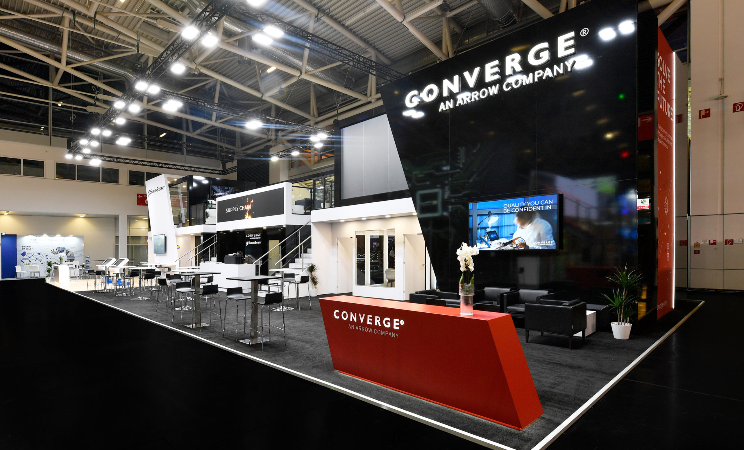 Converge custom trade show exhibit display with modern black and red reception area